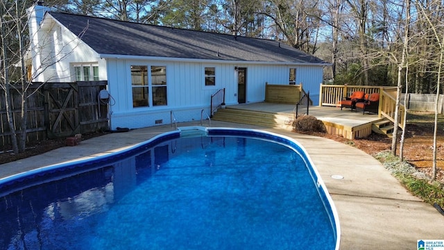 view of swimming pool with fence, a wooden deck, and a fenced in pool