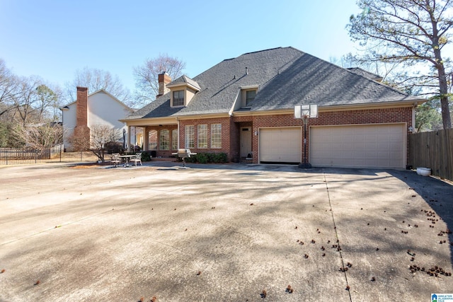 view of front of home featuring brick siding, a shingled roof, concrete driveway, fence, and a garage