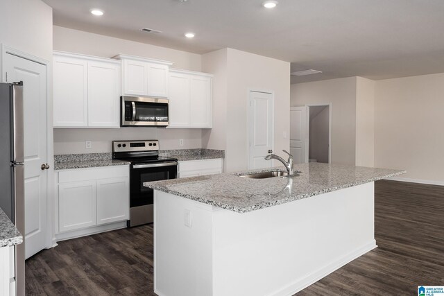 kitchen with appliances with stainless steel finishes, a kitchen island with sink, a sink, and white cabinetry