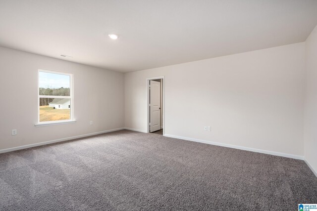 empty room featuring carpet and baseboards