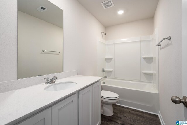 full bath featuring toilet, bathtub / shower combination, wood finished floors, and visible vents