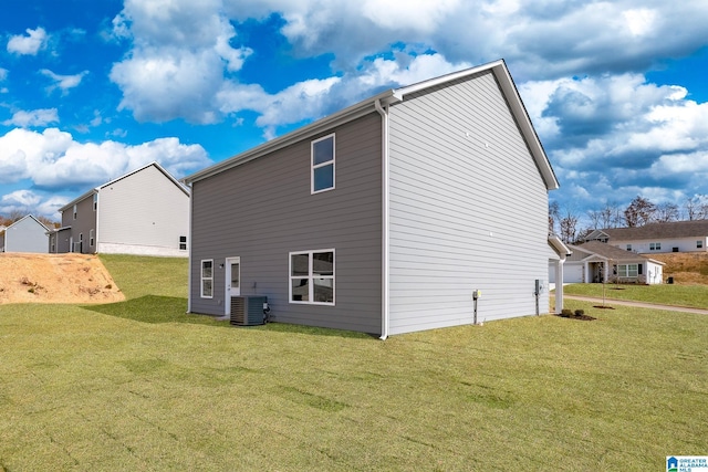 view of side of property with central AC unit and a lawn