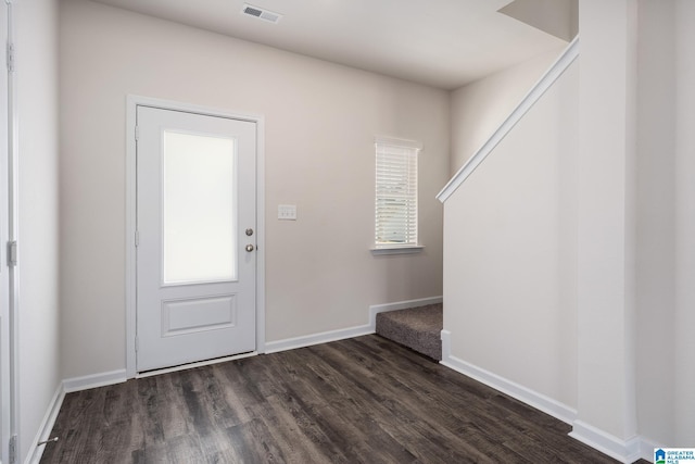 foyer entrance with baseboards, visible vents, and dark wood-type flooring