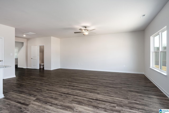 empty room with a ceiling fan, dark wood-style flooring, visible vents, and baseboards