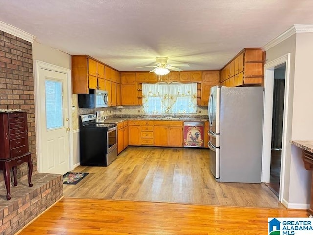 kitchen featuring light wood-style floors, plenty of natural light, stainless steel appliances, and a sink