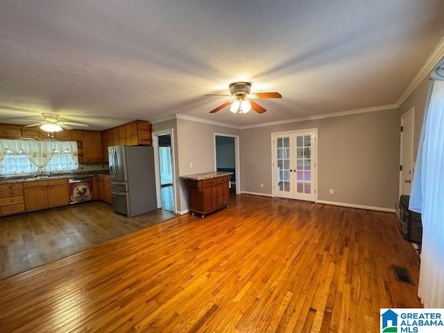 kitchen with wood finished floors, visible vents, open floor plan, freestanding refrigerator, and brown cabinetry