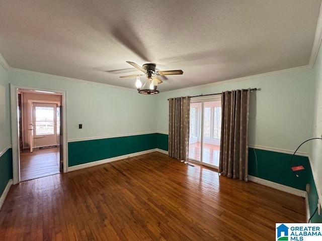 unfurnished room featuring crown molding, dark wood-type flooring, ceiling fan, a textured ceiling, and baseboards