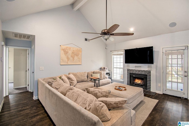 living room featuring dark wood-style floors, a fireplace, visible vents, and beamed ceiling