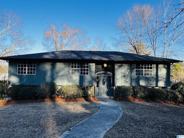 split foyer home featuring roof with shingles and stucco siding