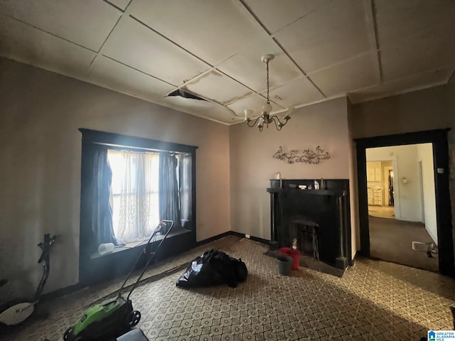 living room featuring baseboards, a fireplace, and a chandelier