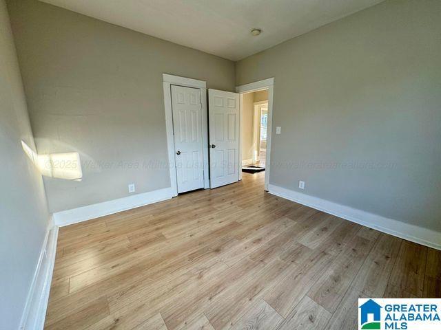 unfurnished bedroom with light wood-type flooring and baseboards