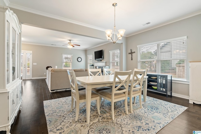 dining space featuring baseboards, visible vents, dark wood-type flooring, crown molding, and ceiling fan with notable chandelier