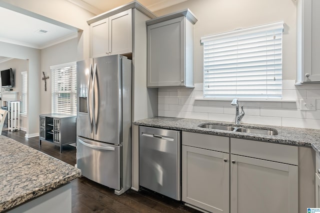 kitchen with decorative backsplash, appliances with stainless steel finishes, dark wood-style flooring, crown molding, and a sink