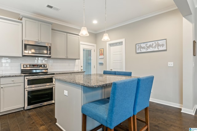 kitchen featuring visible vents, stainless steel appliances, backsplash, and ornamental molding