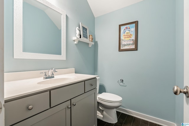 half bathroom featuring toilet, baseboards, wood finished floors, and vanity