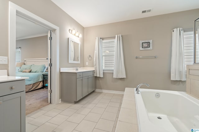 ensuite bathroom featuring visible vents, ensuite bath, a garden tub, vanity, and a healthy amount of sunlight