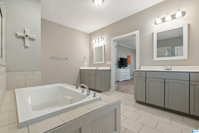 full bath featuring a sink, two vanities, a bath, and tile patterned floors