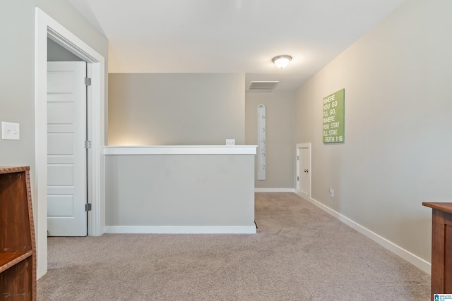 hall with carpet flooring, visible vents, and baseboards