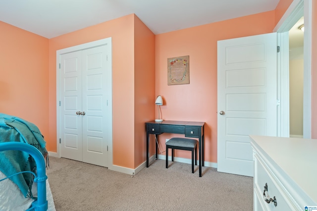 bedroom with light carpet, baseboards, and a closet