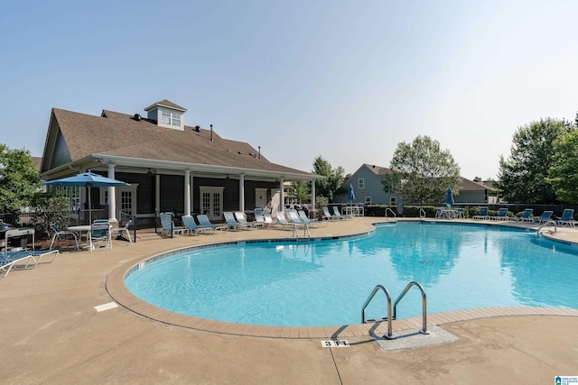 community pool featuring french doors, a patio, and fence