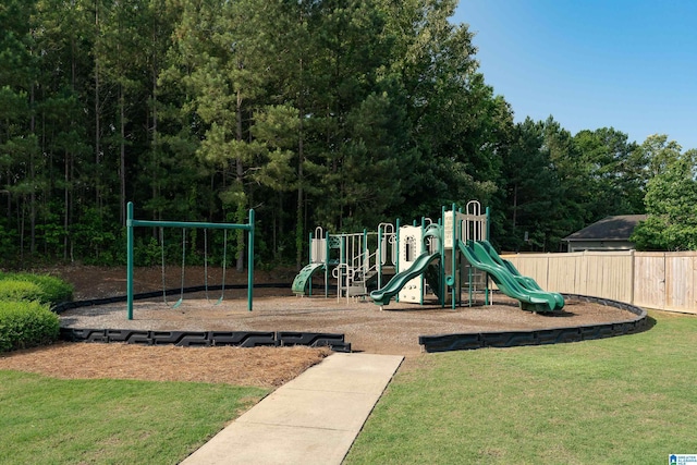 community jungle gym featuring a lawn and fence