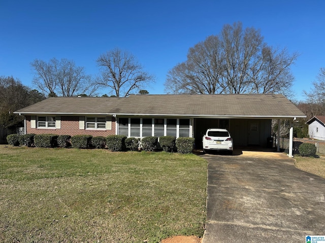 ranch-style home featuring a front yard, brick siding, driveway, and an attached carport