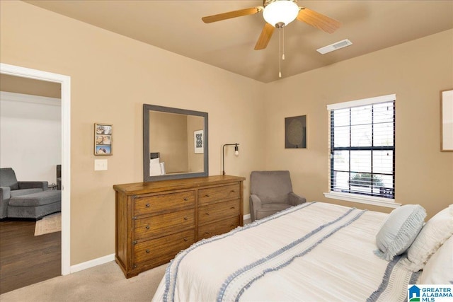 bedroom featuring light colored carpet, visible vents, ceiling fan, and baseboards