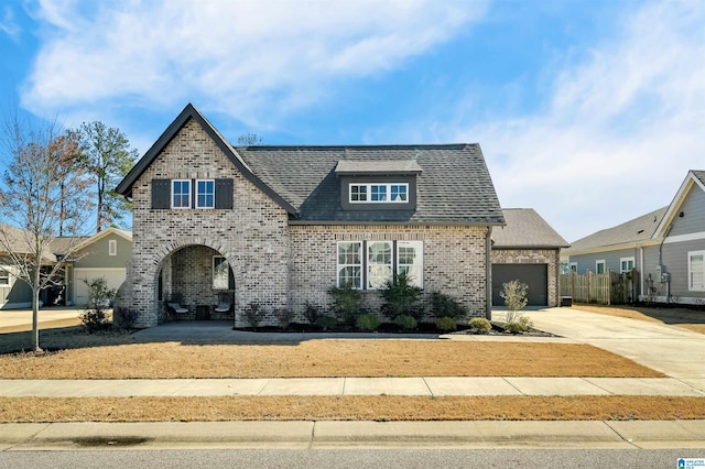 view of front of house featuring a garage, roof with shingles, concrete driveway, and brick siding