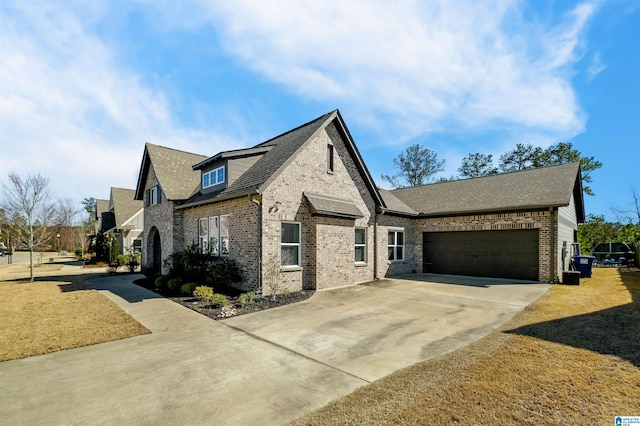 view of front of home featuring a garage, driveway, brick siding, and roof with shingles