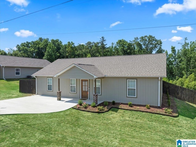 ranch-style house featuring a front yard, roof with shingles, and fence