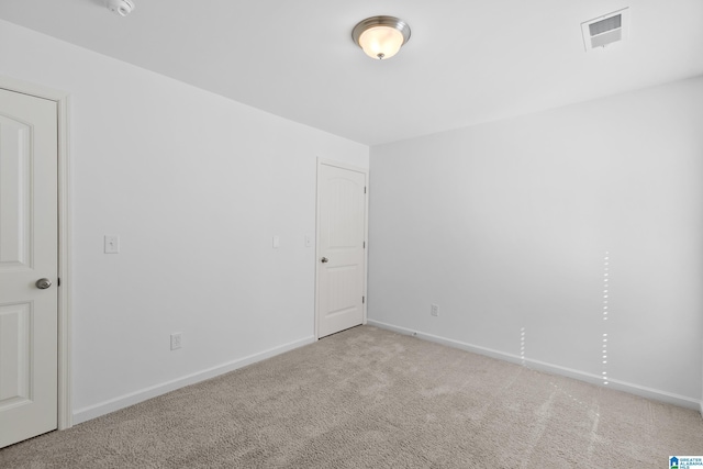 unfurnished room with light colored carpet, visible vents, and baseboards