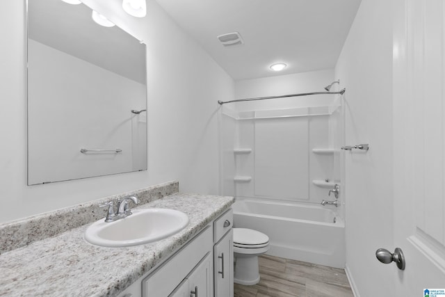 full bathroom featuring toilet, wood finished floors, visible vents, vanity, and bathing tub / shower combination