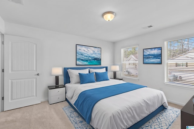 bedroom with light colored carpet, visible vents, and baseboards