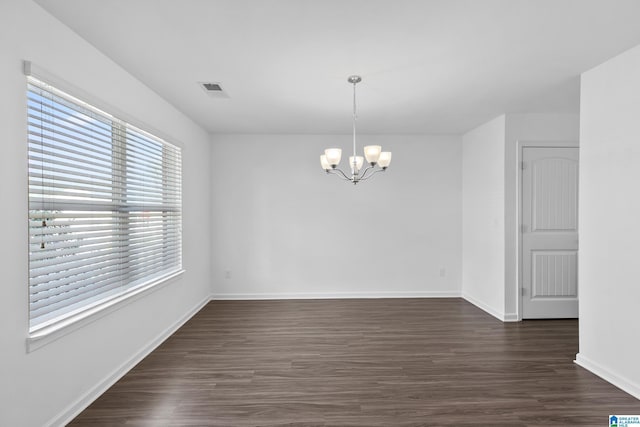 interior space featuring dark wood finished floors, visible vents, a notable chandelier, and baseboards