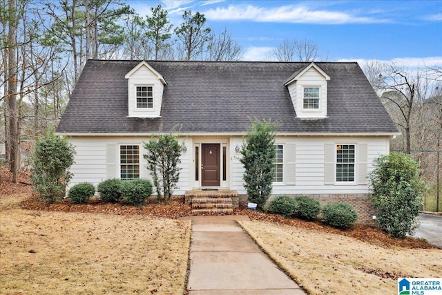 new england style home featuring roof with shingles