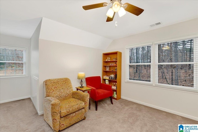 sitting room with lofted ceiling, plenty of natural light, and light colored carpet