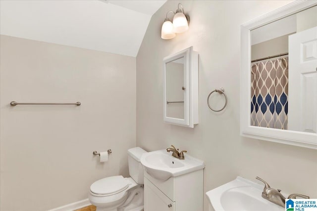 full bathroom featuring toilet, vaulted ceiling, and vanity