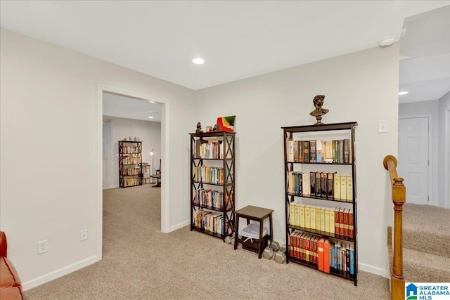 living area featuring recessed lighting, baseboards, and light colored carpet