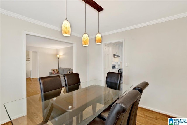 dining area featuring ornamental molding, light wood-type flooring, and baseboards