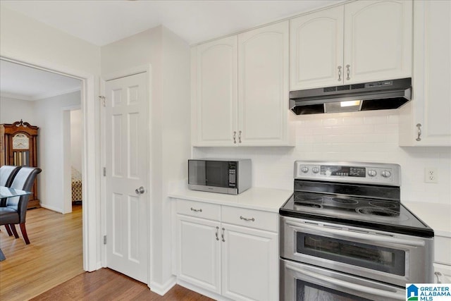 kitchen featuring light countertops, range with two ovens, white cabinetry, and under cabinet range hood