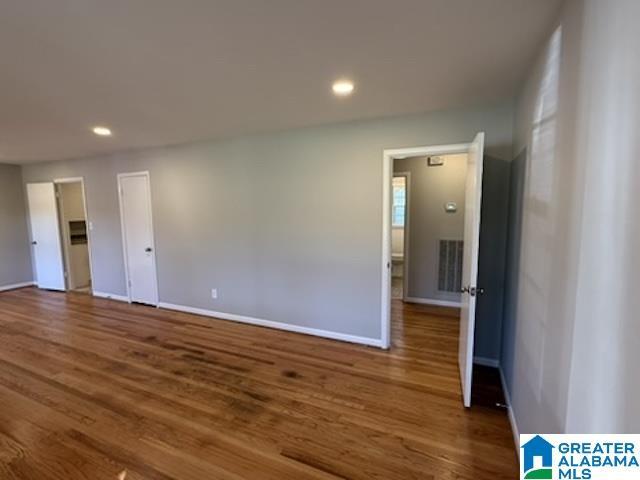 spare room with baseboards, dark wood-type flooring, and recessed lighting