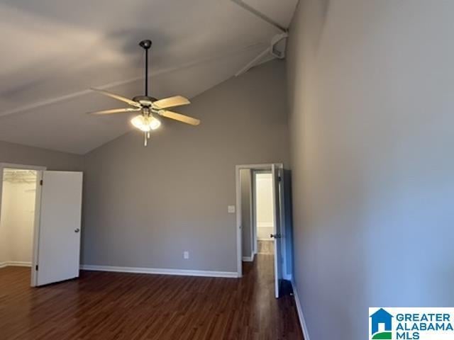 unfurnished room with dark wood-style floors, ceiling fan, high vaulted ceiling, and baseboards