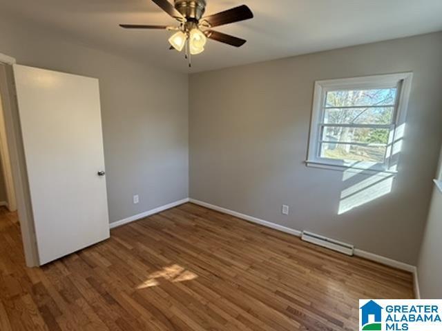 unfurnished bedroom featuring visible vents, ceiling fan, baseboards, and wood finished floors