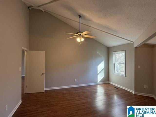 unfurnished room with lofted ceiling, baseboards, dark wood finished floors, and a textured ceiling