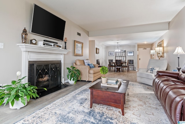 living area featuring light wood-style floors, visible vents, and a fireplace