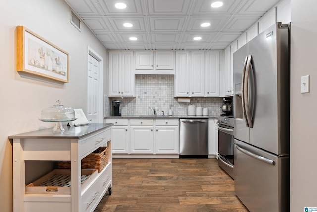 kitchen featuring tasteful backsplash, white cabinets, dark wood-style floors, stainless steel appliances, and recessed lighting