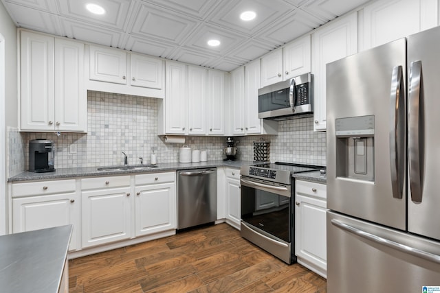 kitchen featuring recessed lighting, stainless steel appliances, dark wood-type flooring, a sink, and white cabinets