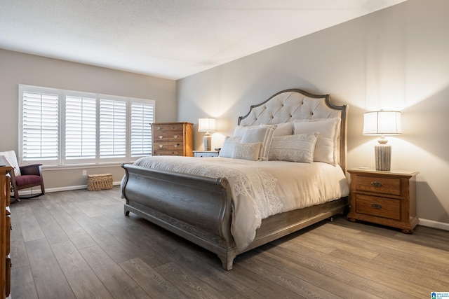 bedroom featuring wood finished floors and baseboards