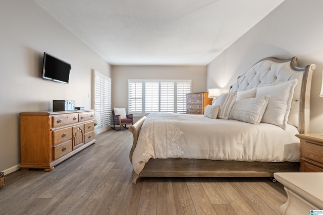 bedroom with baseboards and wood finished floors