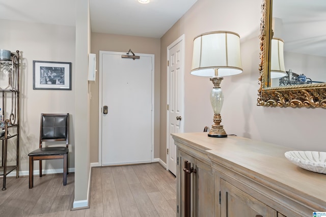 entryway with light wood-style flooring and baseboards